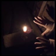 hands open, spread towards a candle